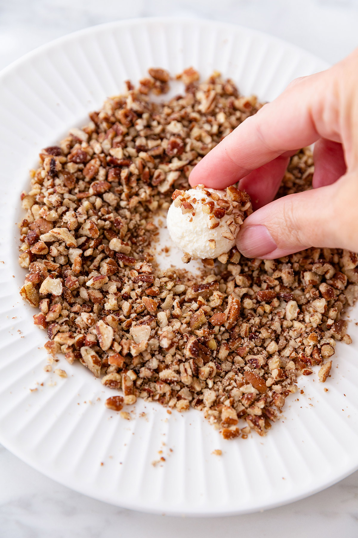 Rolling Mini Cheese Balls in Chopped Nuts